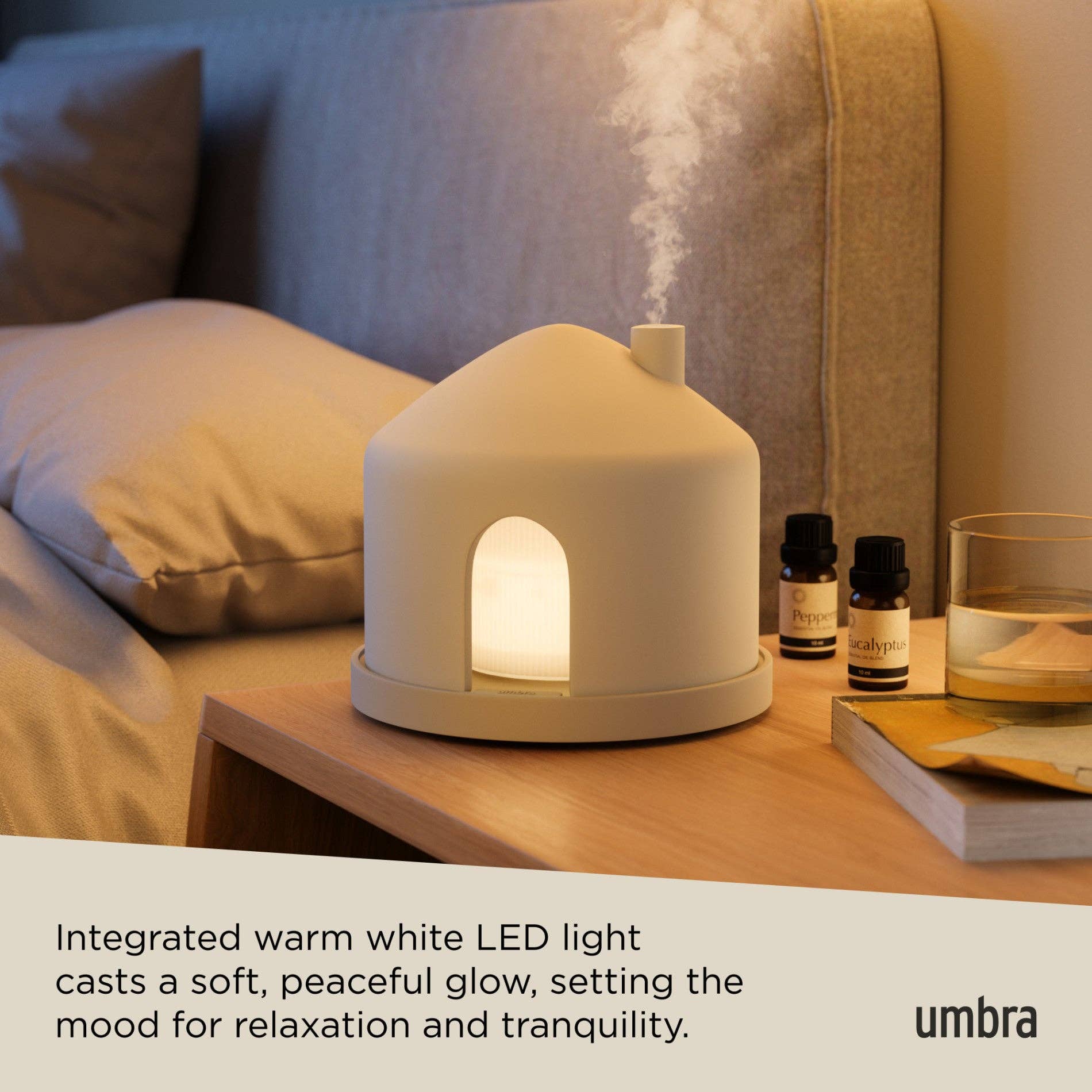 Umbra diffuser on a table with a cozy background, featuring text about its LED light.